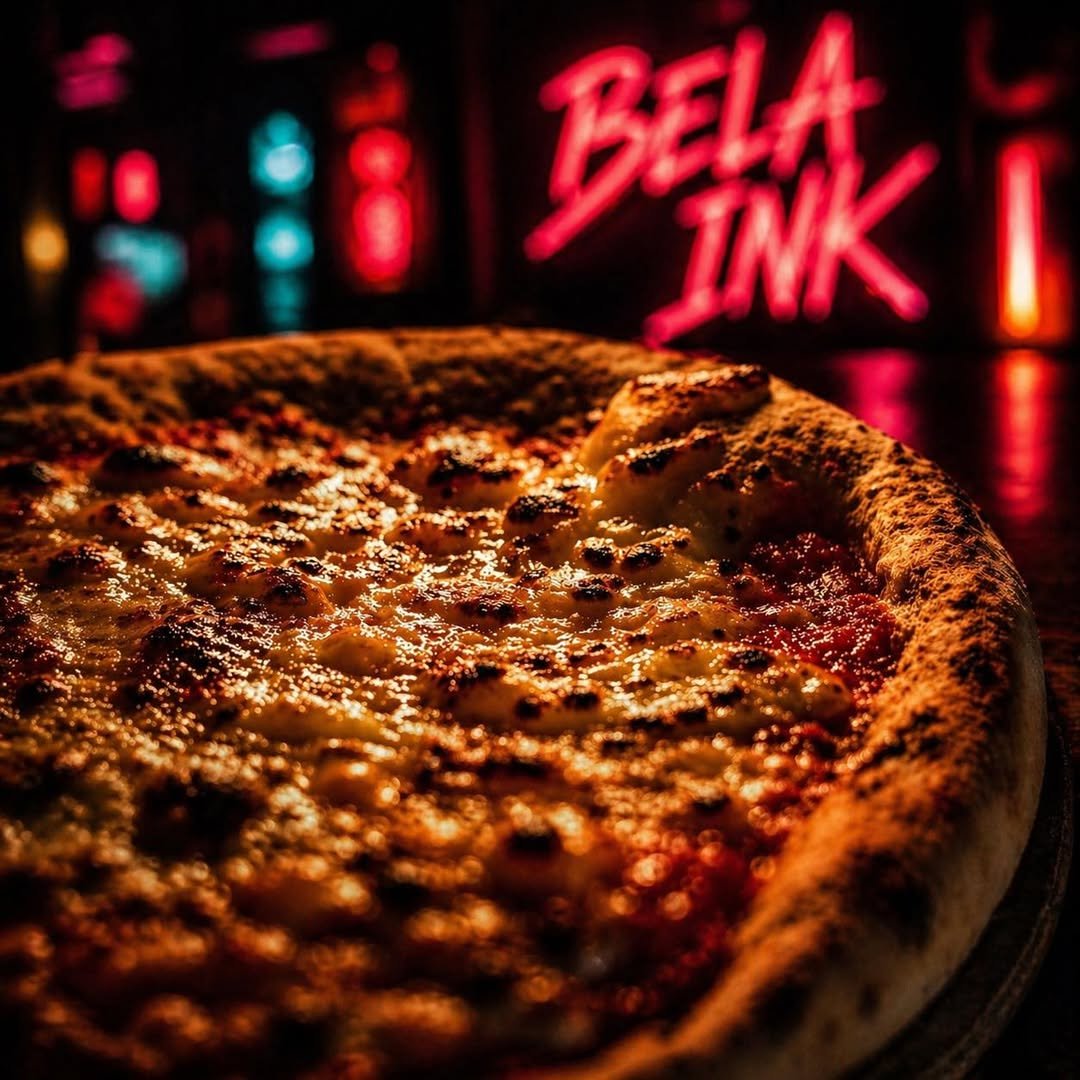 Pizza napolitana Bela Ink frente al letrero de neón BELA INK