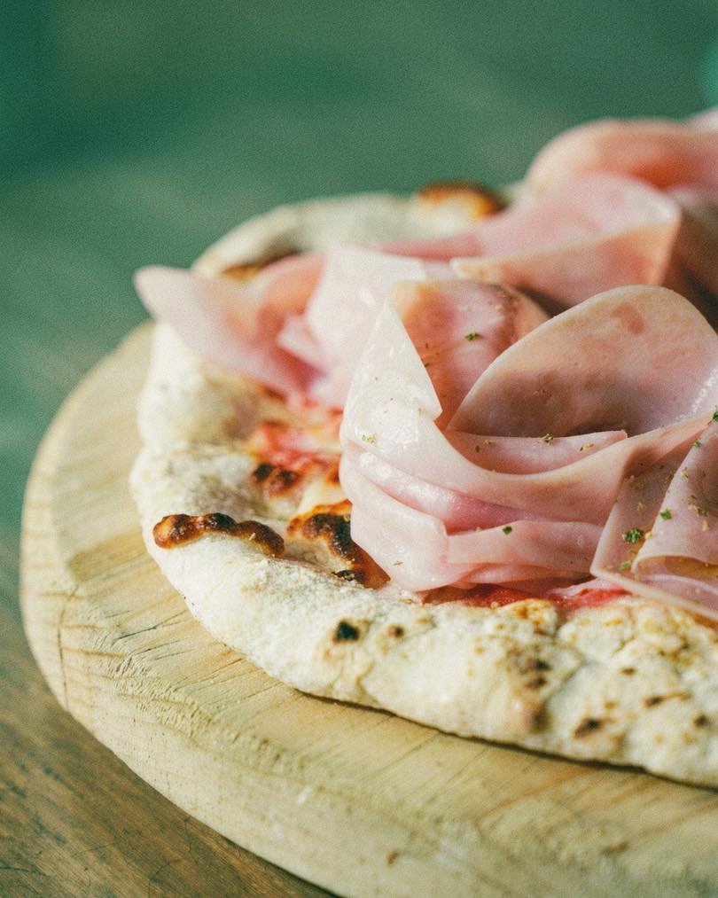 Pizza con mortadela enrollada en rosas